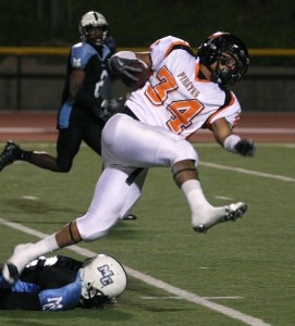 Pirates running back Dominique Morris tramples over a Raiders defender on a run play. Morris had a key touchdown reception on the night to help the Pirates win the 42nd annual Citrus Cup 41-28 Saturday night.